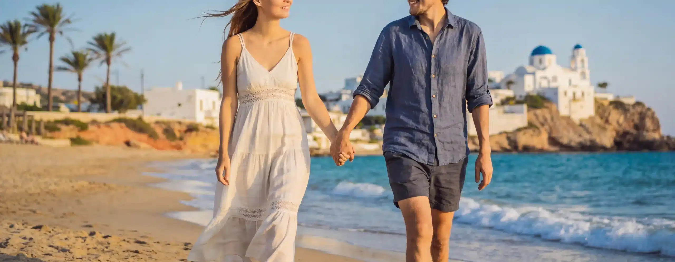 couple holding hands walking at the beach